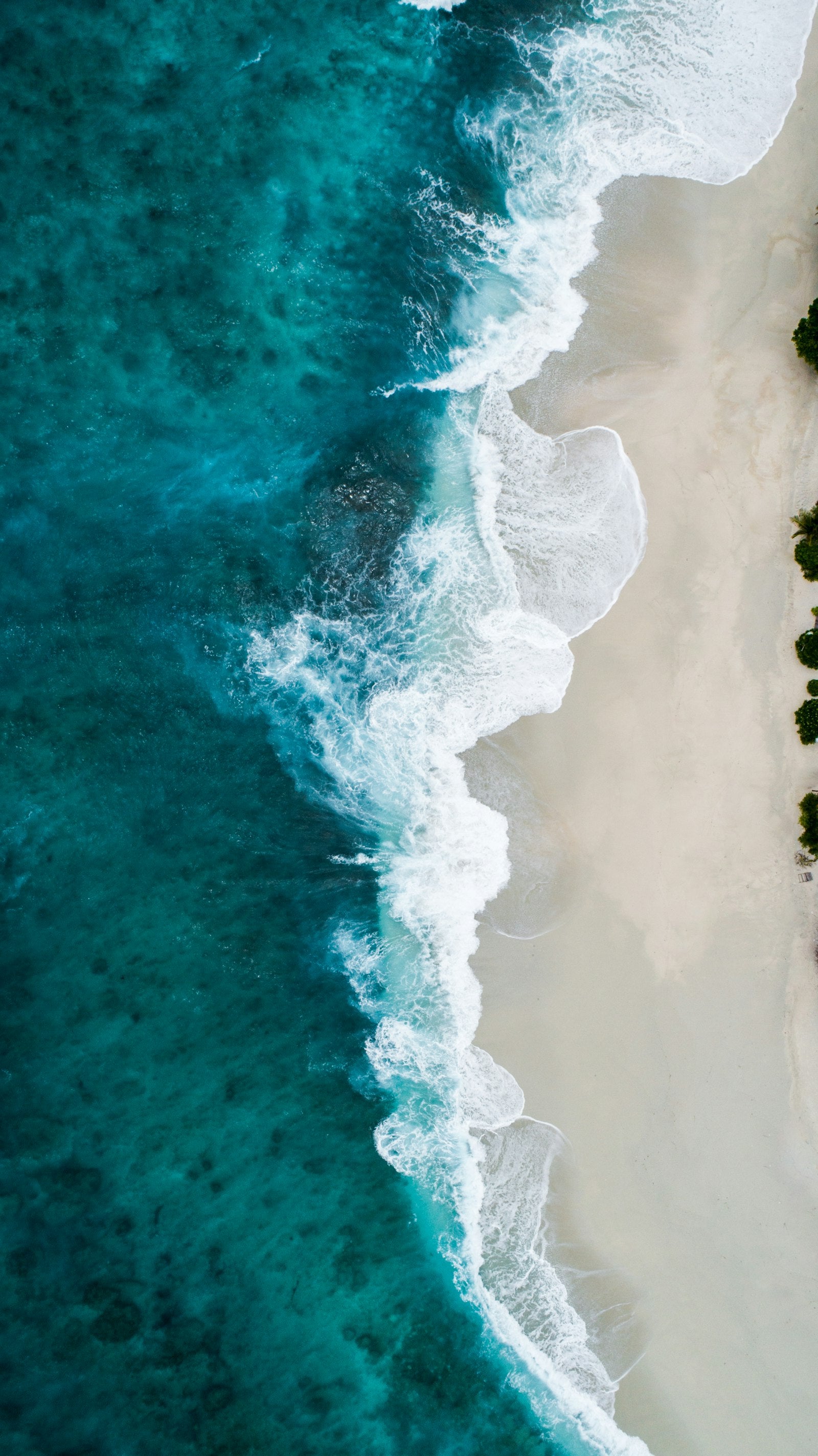 Aerial view of surf breaking along a Northern California coastline